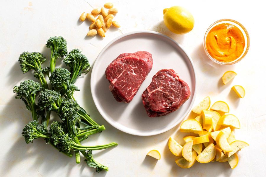 Steaks and romesco with baby broccoli, summer squash, and almonds
