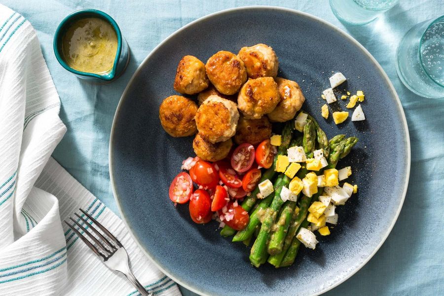 Chicken meatballs with tomato salad and asparagus mimosa