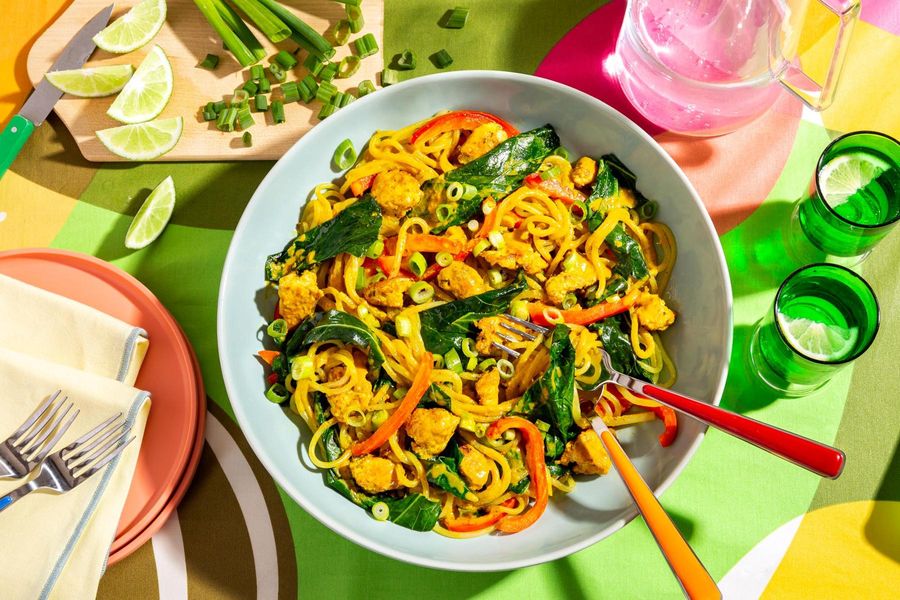 Curry chicken noodle bowls with broccoli leaves and bell pepper