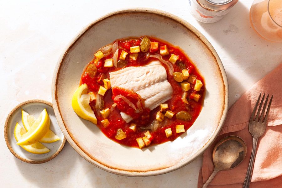Poached cod in tomato broth with potatoes and raisins