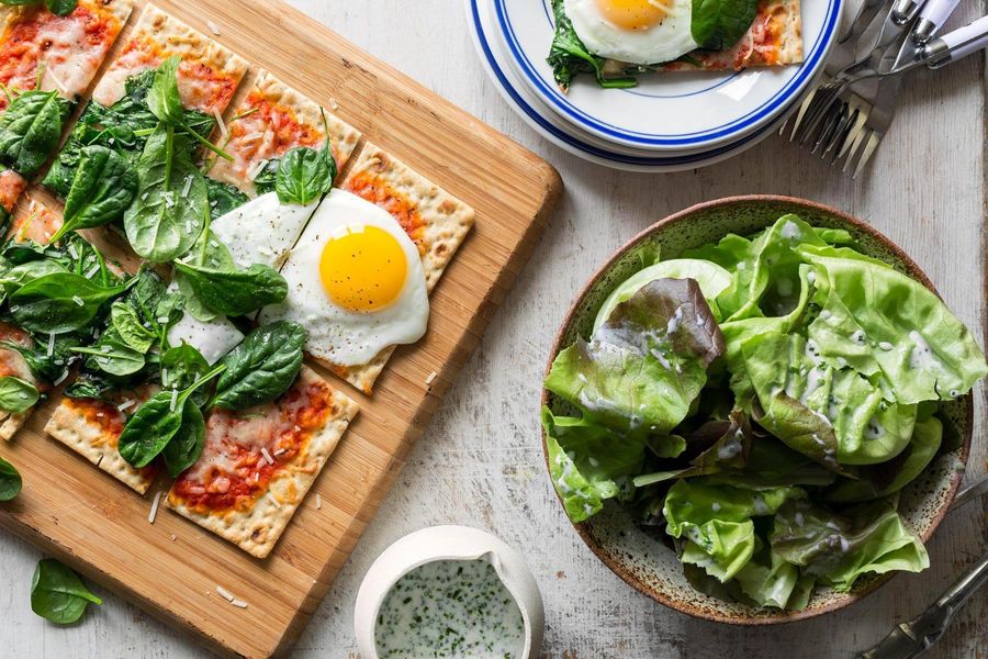 Lavash pizzas with spinach, mozzarella, and fried eggs