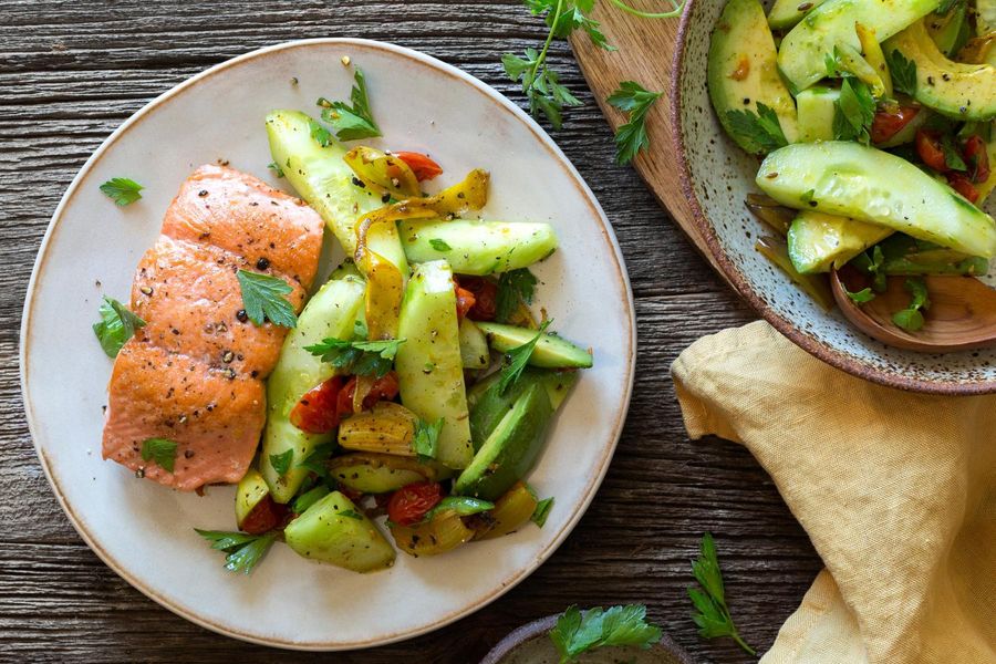 Salmon with roasted cherry tomatoes and avocado-cucumber salad