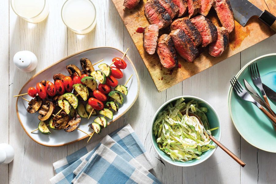 Spicy chipotle-rubbed steaks with vegetable skewers and “creamy” slaw