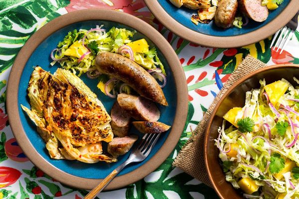 Pork sausages with cabbage “steaks” and pineapple slaw