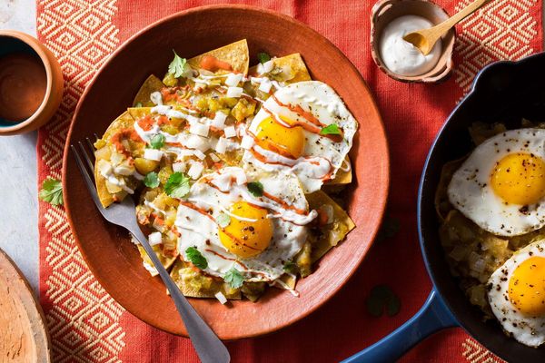Red, white, and green chilaquiles with fried eggs