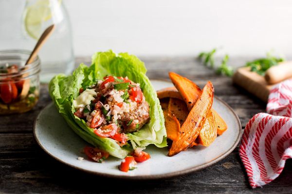 Lettuce-wrapped turkey burgers with tomato relish and sweet potato fries