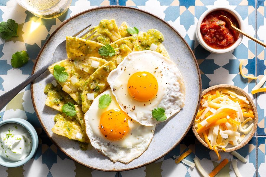 Red, white, and green chilaquiles with fried eggs