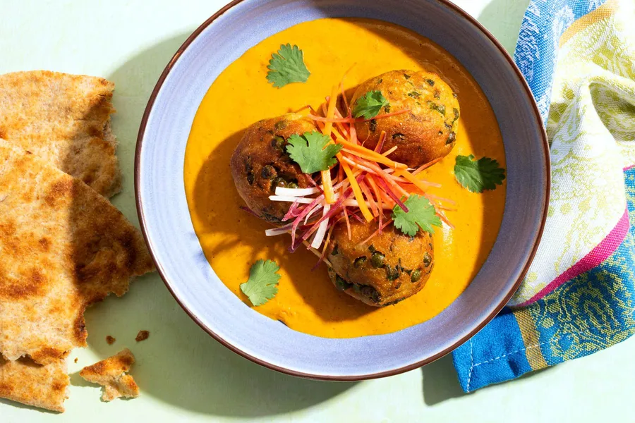 Malai potato kofta dumplings with curry sauce and toasted naan