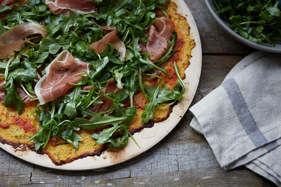 Paleo pizza with arugula and prosciutto