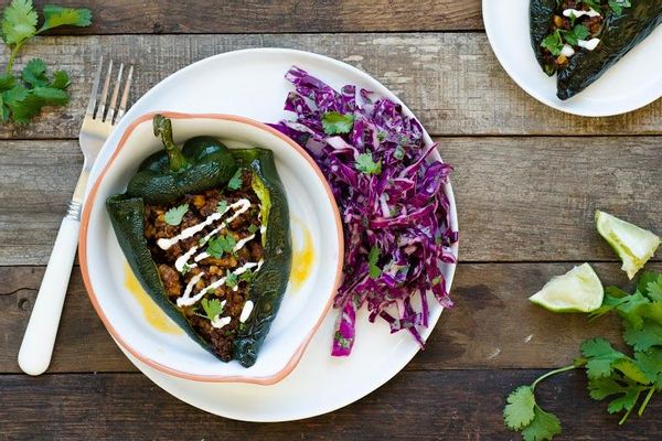 Walnut-stuffed poblano peppers with lime crema and red cabbage slaw