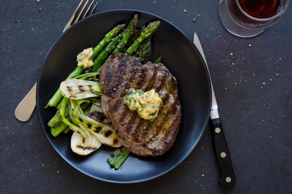 Seared steak with basil butter, asparagus and spring onions