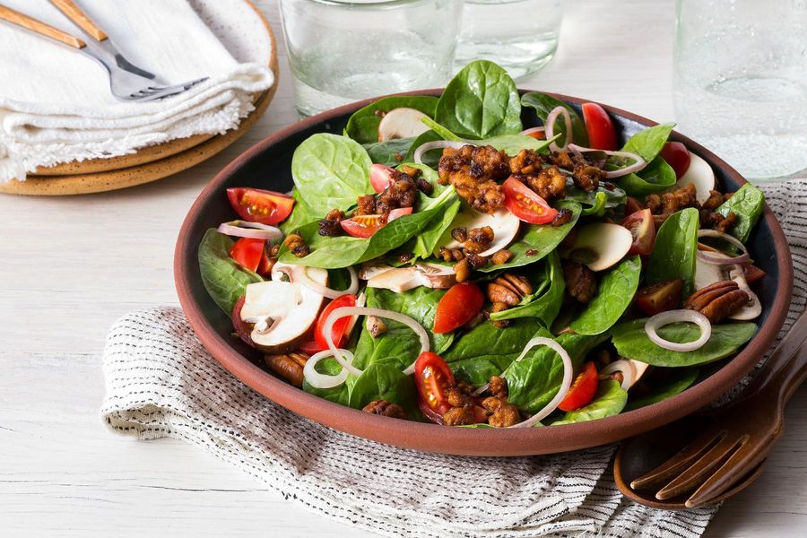 Spinach salad with tomatoes, spicy tempeh “bacon” bits, and pecans