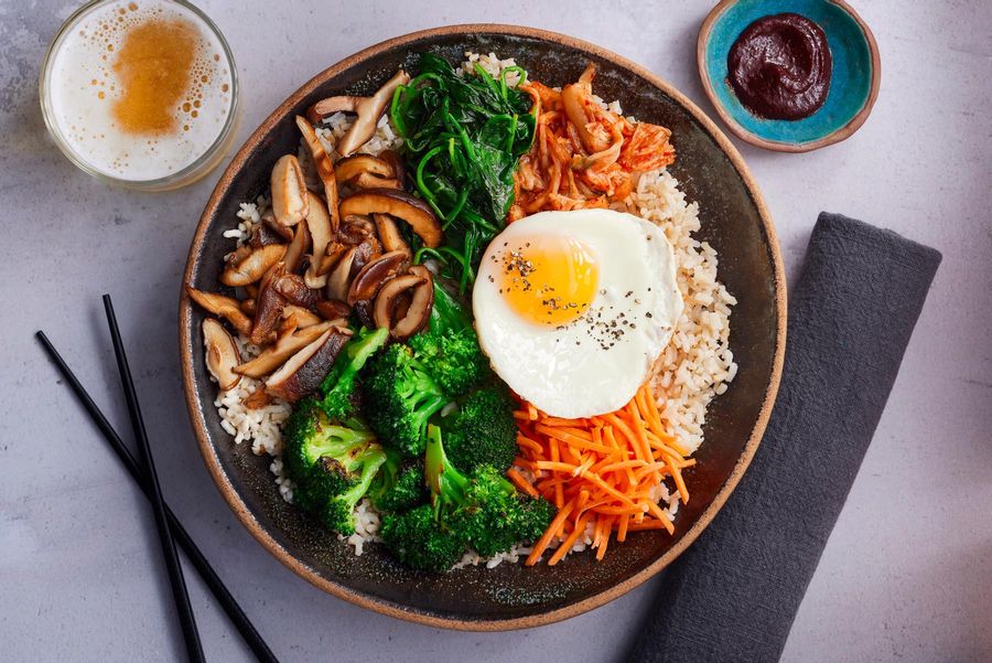 Bibimbap with Korean-style vegetables, brown rice, and fried eggs