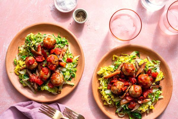 Meatballs with mushroom ragù over wilted cabbage