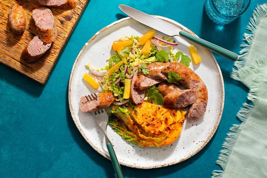 Pork sausages with cabbage “steaks” and pineapple slaw