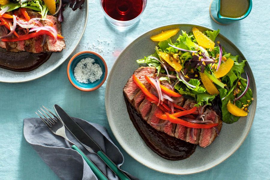Pepper and onion–smothered Black Angus steaks with citrus salad