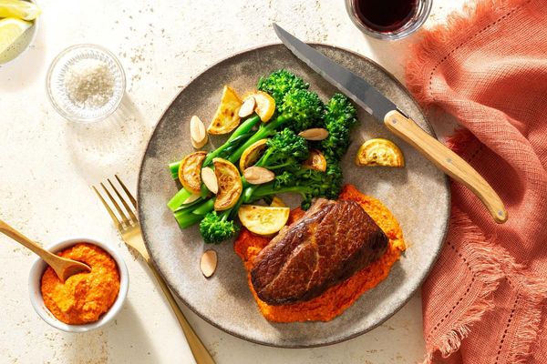 Steaks and romesco with baby broccoli, summer squash, and almonds