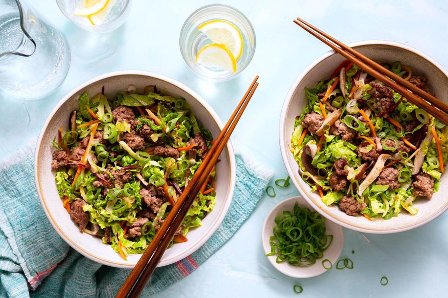 Egg roll in a bowl with stir-fried mushrooms, carrots, and cabbage