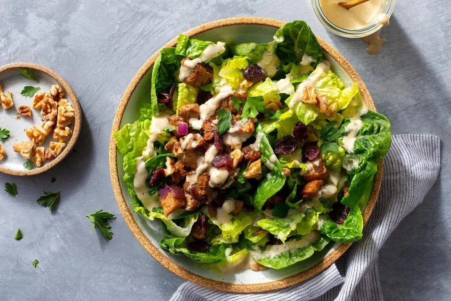 Pork chop salad with dried cranberries, walnuts, and Caesar dressing
