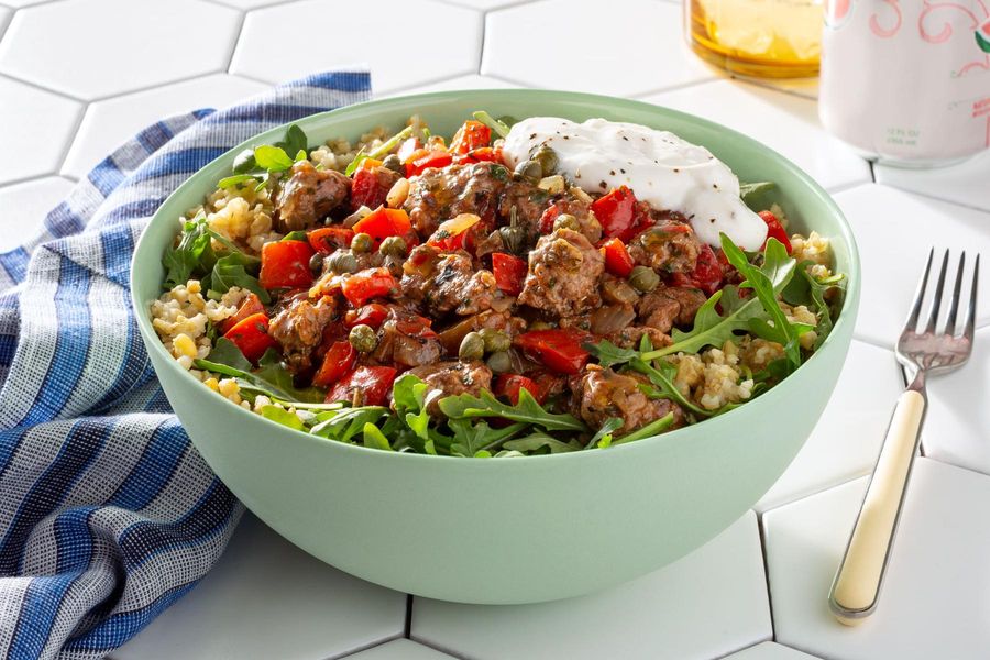 Greek grain bowl with lamb ragout, fresh arugula, and lemon yogurt