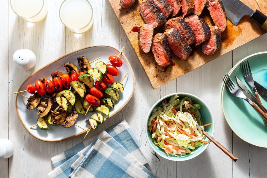 Spicy chipotle-rubbed steaks with vegetable skewers and “creamy” slaw