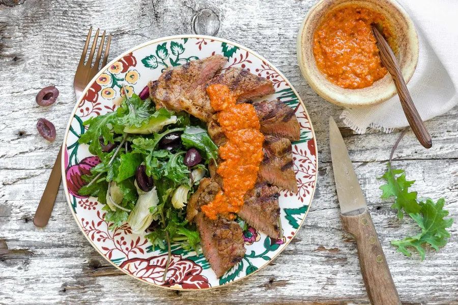 Steak with romesco sauce and kale salad