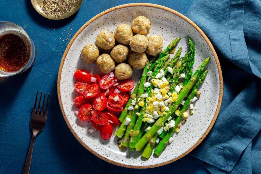 Chicken meatballs with tomato salad and asparagus mimosa