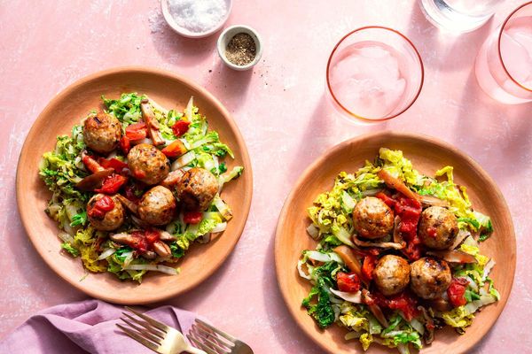 Meatballs with mushroom ragù over wilted cabbage