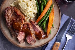 Steaks with peppercorn sauce, garlicky vegetables, and cauliflower mash
