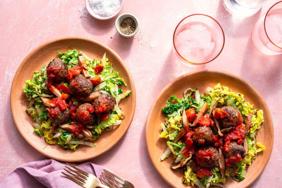 Meatballs with mushroom ragù over wilted cabbage