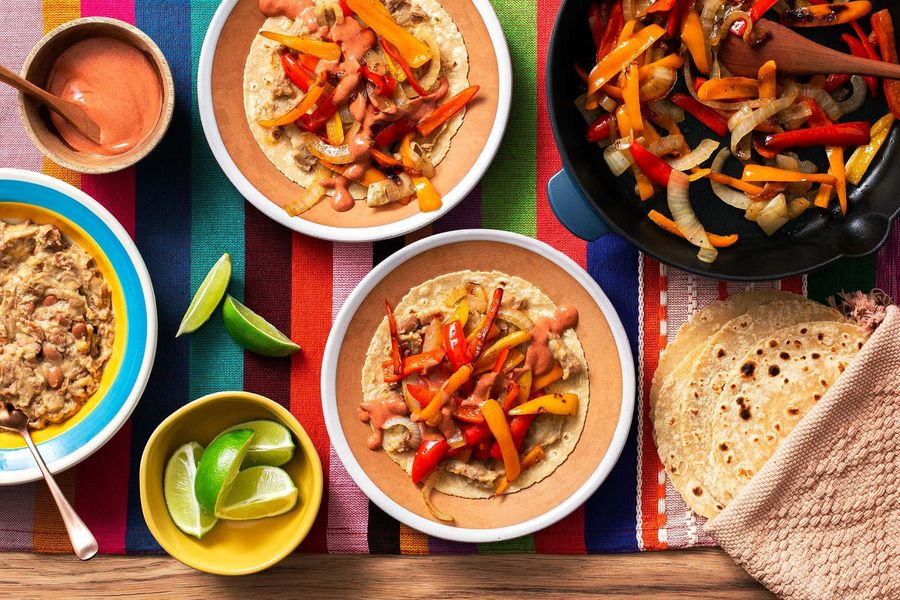 Tex-Mex vegetable fajitas with cheesy refried beans and achiote crema