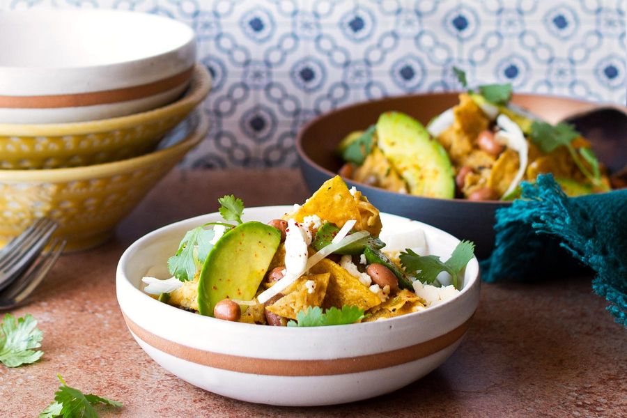 Chilaquiles verdes with soft-scrambled eggs, avocado, and queso fresco