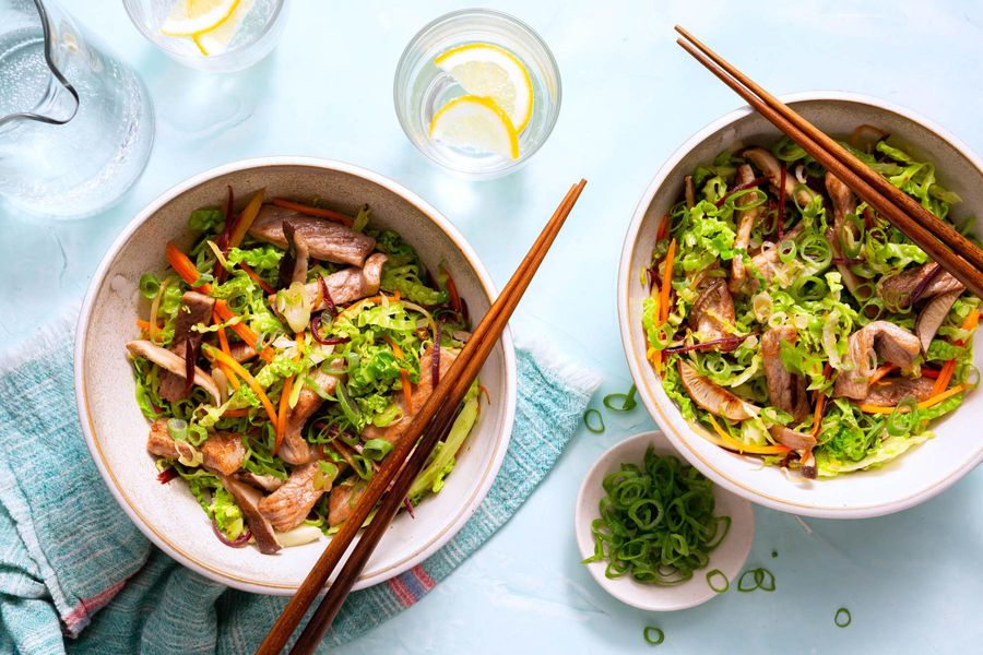 Egg roll in a bowl with stir-fried mushrooms, carrots, and cabbage