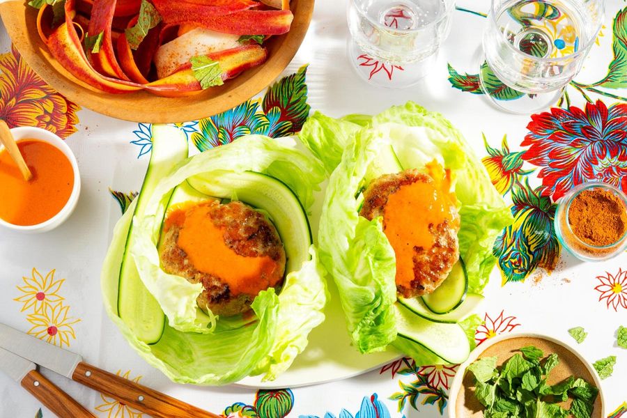 Lettuce-wrapped turkey burgers with spicy chraime carrot salad