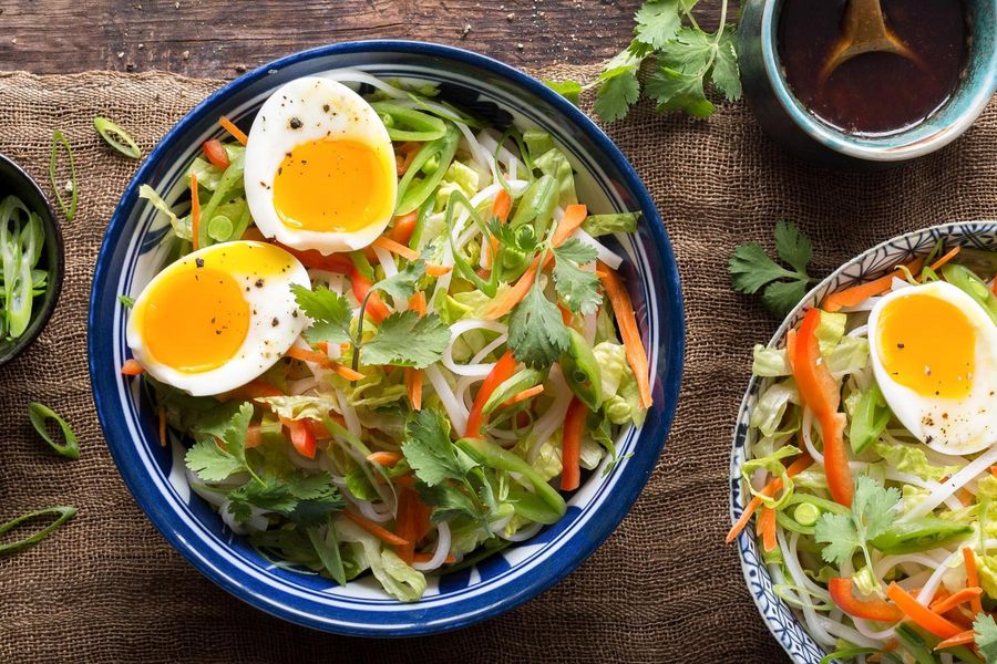 Asian rice noodle bowls with sesame dressing and softcooked eggs