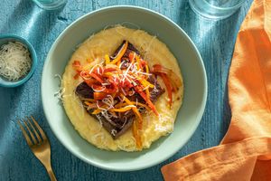 Steak pizzaiola with tomatoes and sweet peppers over creamy polenta