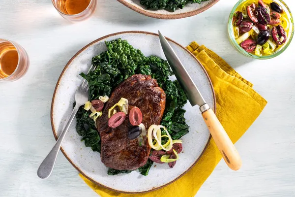 Chicken breasts with olive-leek sauce and sautéed kale