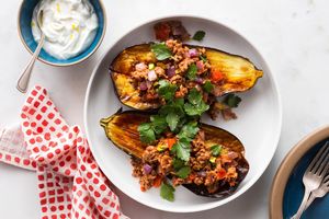 Stuffed eggplant with spiced lamb, pistachios, and lemon-yogurt sauce