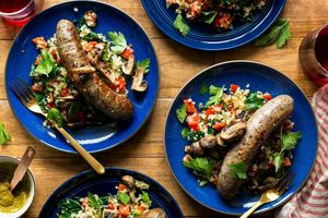 Italian sausages with warm cauliflower-kale salad and artichoke romesco