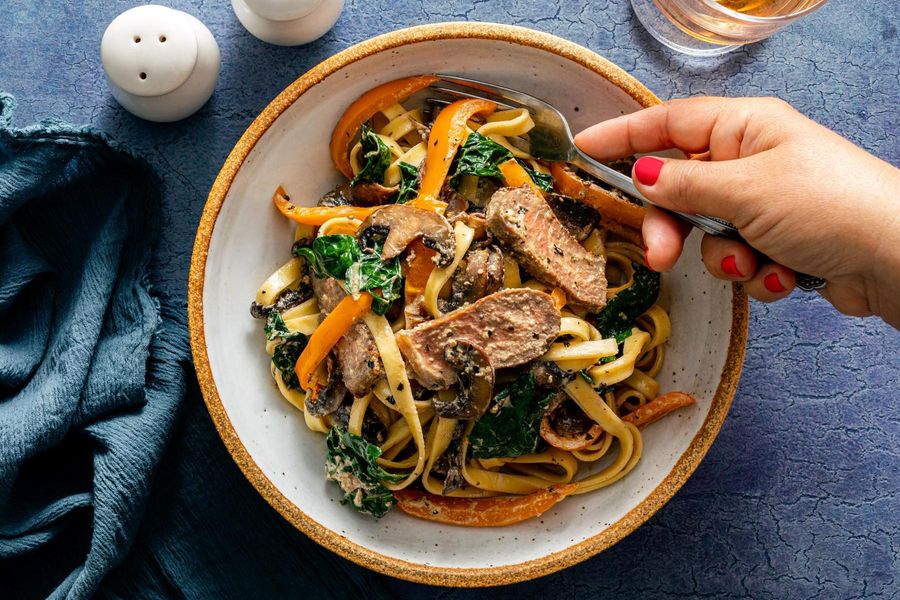 Fettuccine Alfredo with Black Angus steaks, mushrooms, and kale