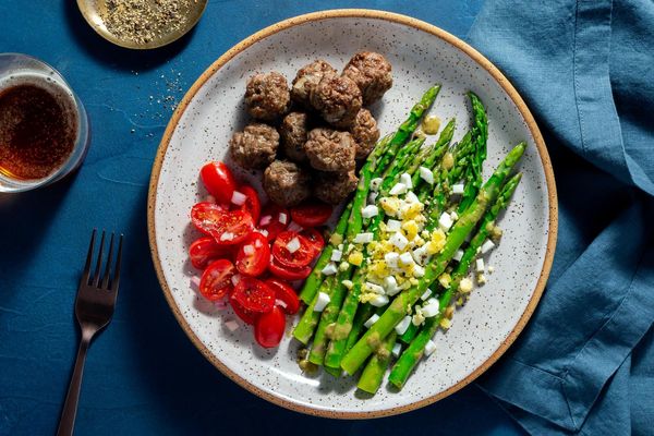 Chicken meatballs with tomato salad and asparagus mimosa