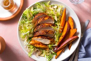 Paprika-spiced chicken with frisée salad and sweet potato wedges