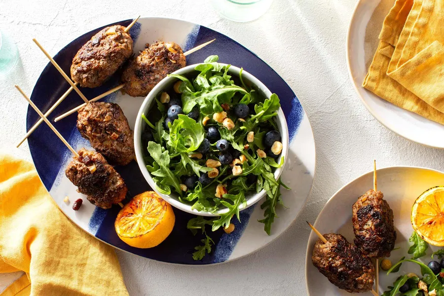 Souzoukaklia ground beef skewers with arugula-blueberry salad