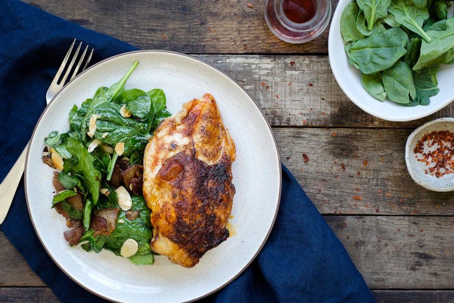 Baked paprika chicken with spinach, bacon and almond salad