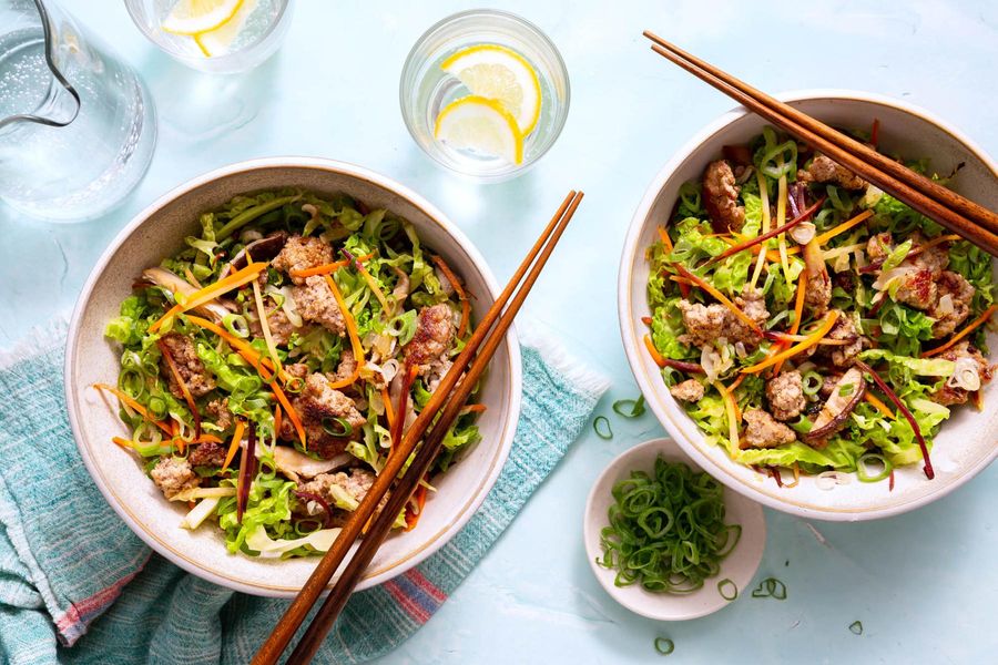 Egg roll in a bowl with stir-fried mushrooms, carrots, and cabbage