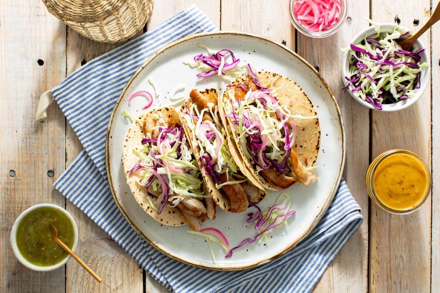 Mojo tacos with shredded cabbage, pickled onions, and salsa verde