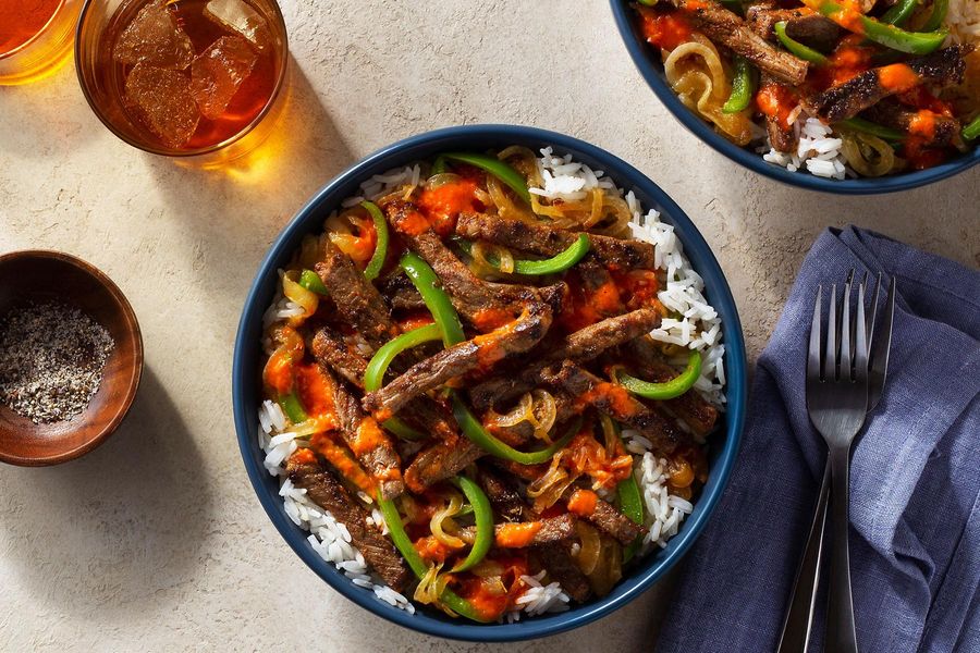 Cajun-spiced steak strips over white rice with red pepper vinaigrette