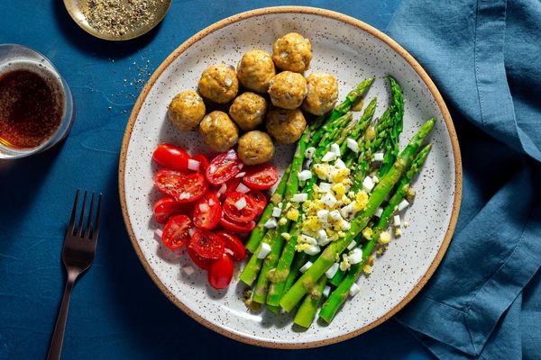 Chicken meatballs with tomato salad and asparagus mimosa
