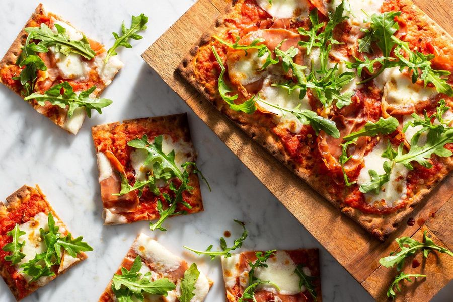 Prosciutto pizzas with fresh mozzarella and arugula salad