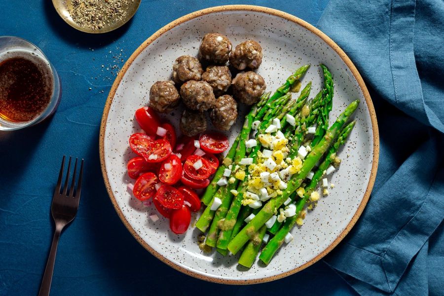 Meatballs with tomato salad and asparagus mimosa